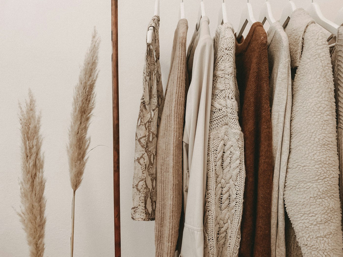Neutral-toned ready-to-wear garments on a clothing rail